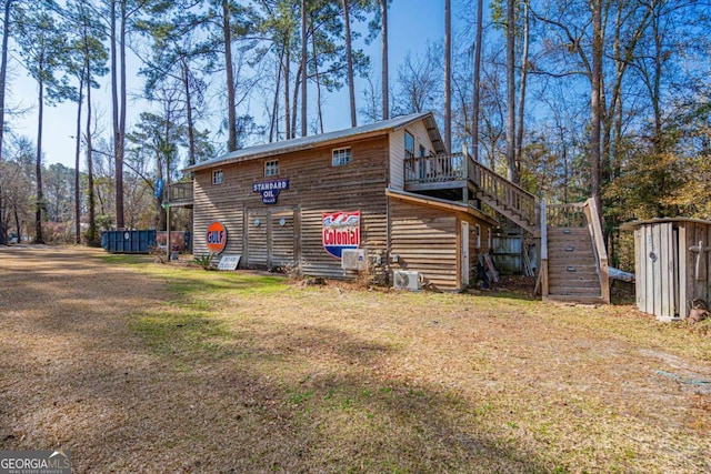 rear view of property with a wooden deck, a storage shed, and a lawn