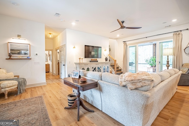 living room with light hardwood / wood-style flooring and ceiling fan