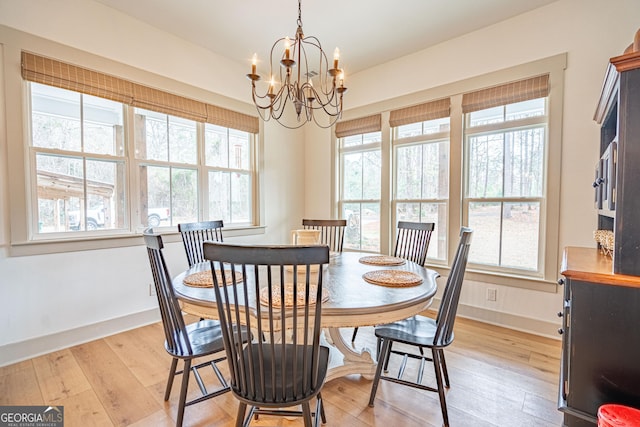 dining area with a wealth of natural light, a notable chandelier, and light hardwood / wood-style floors