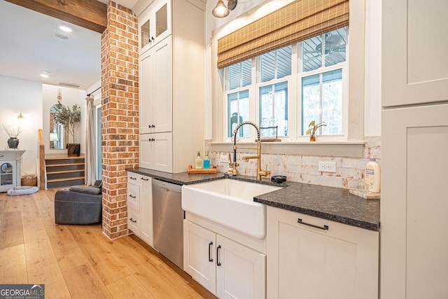 kitchen featuring white cabinetry, dishwasher, sink, dark stone countertops, and light hardwood / wood-style flooring