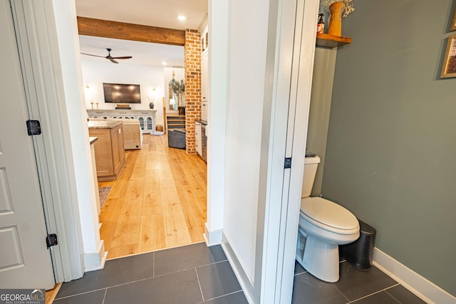 bathroom with tile patterned flooring, vanity, beam ceiling, and toilet