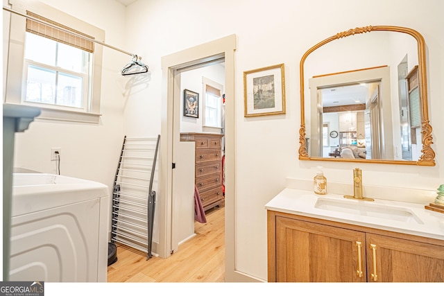 bathroom with wood-type flooring, washer / dryer, and vanity