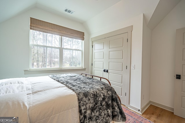 bedroom with hardwood / wood-style flooring and vaulted ceiling