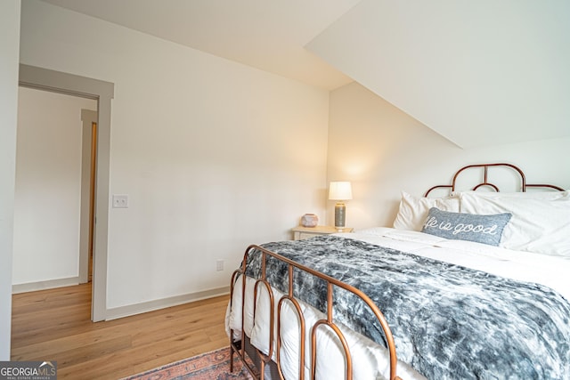 bedroom featuring hardwood / wood-style flooring and vaulted ceiling