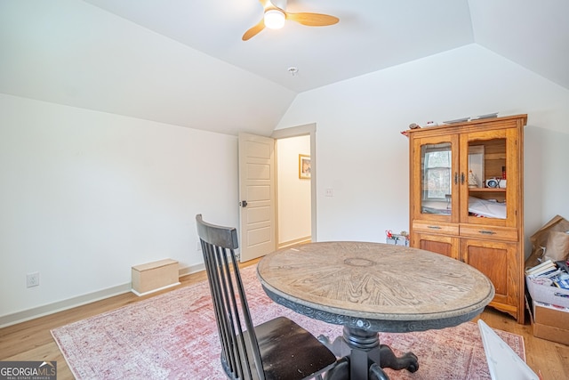 dining space with vaulted ceiling, ceiling fan, and light hardwood / wood-style flooring