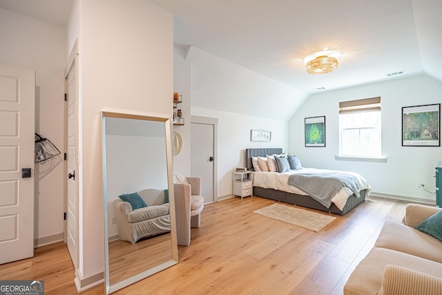 bedroom with lofted ceiling and light wood-type flooring