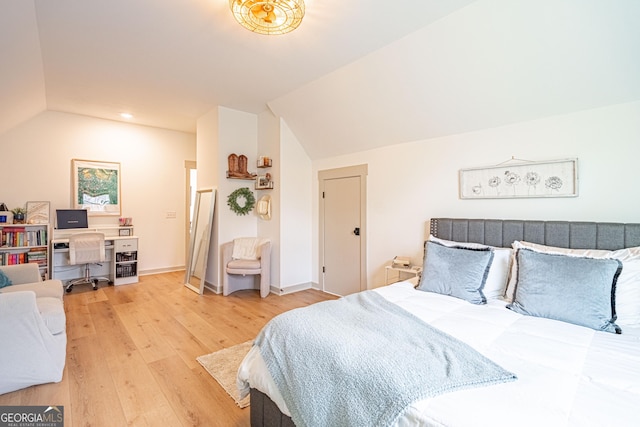 bedroom featuring lofted ceiling and light hardwood / wood-style flooring