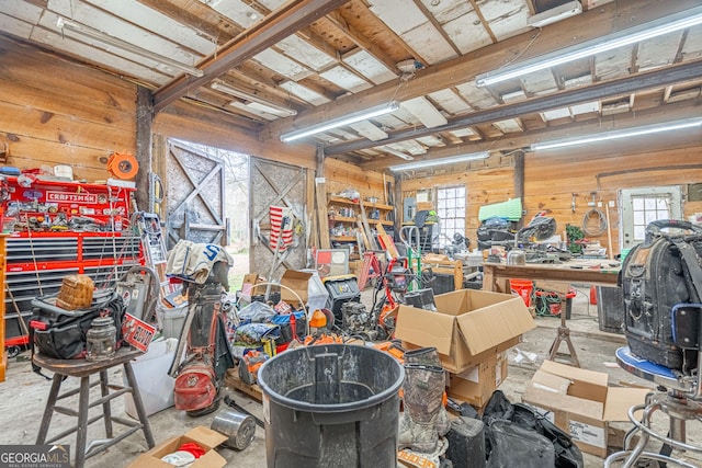 misc room featuring a workshop area and wood walls