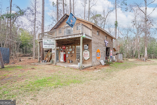 exterior space featuring a wooden deck and a front yard