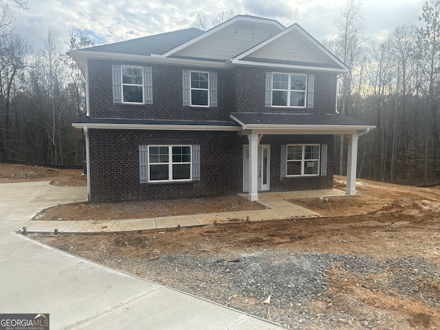 view of front facade with covered porch and brick siding