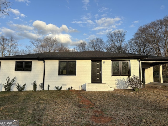 ranch-style home with an attached carport, crawl space, a front lawn, and brick siding