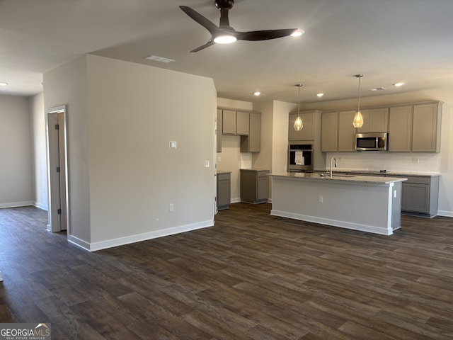 kitchen with stainless steel appliances, sink, gray cabinetry, and a center island with sink