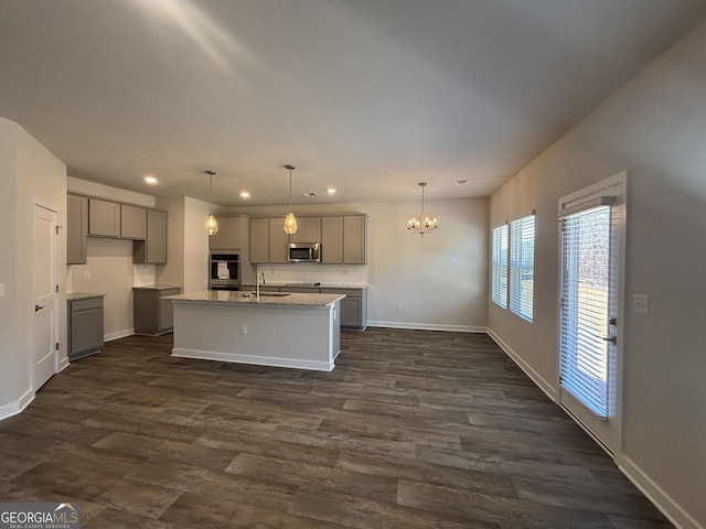 kitchen with sink, gray cabinetry, a center island with sink, and dark hardwood / wood-style flooring