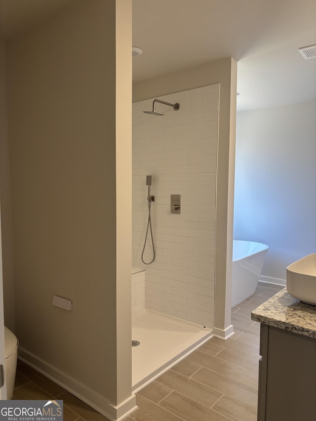 full bathroom with shower with separate bathtub, vanity, and toilet