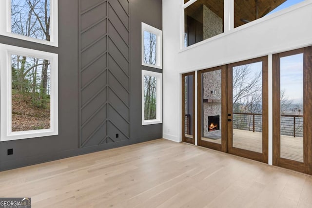 entryway with a towering ceiling and light hardwood / wood-style flooring