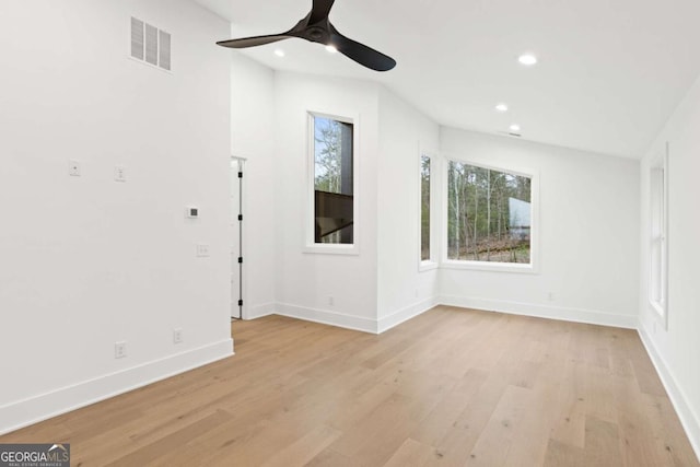 empty room with ceiling fan and light hardwood / wood-style floors