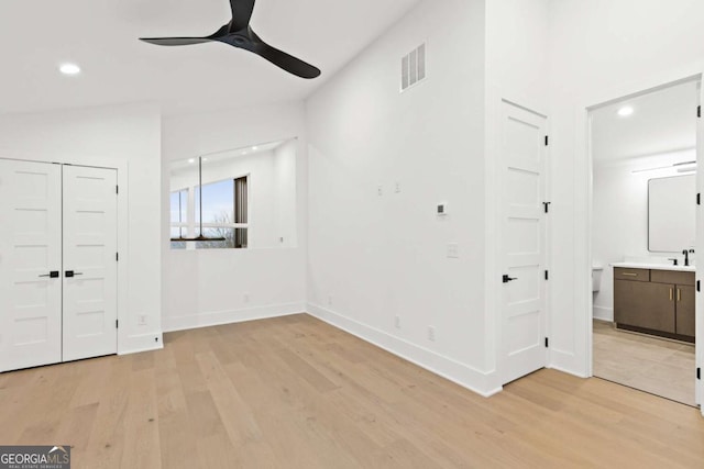 unfurnished bedroom featuring connected bathroom, ceiling fan, and light wood-type flooring