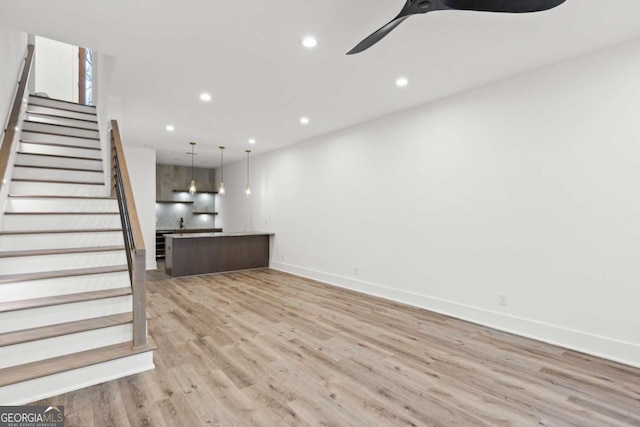 unfurnished living room with ceiling fan and light hardwood / wood-style flooring