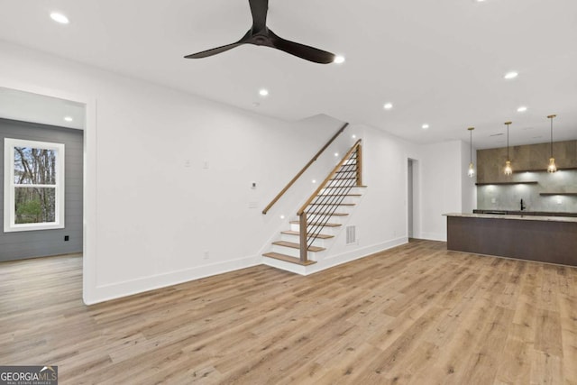 unfurnished living room featuring light hardwood / wood-style flooring and ceiling fan