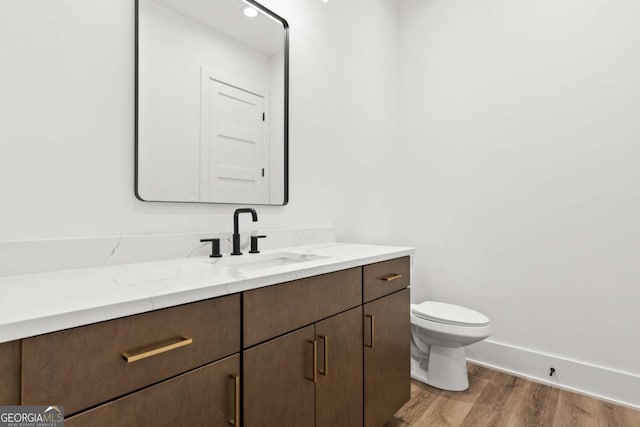 bathroom with vanity, wood-type flooring, and toilet