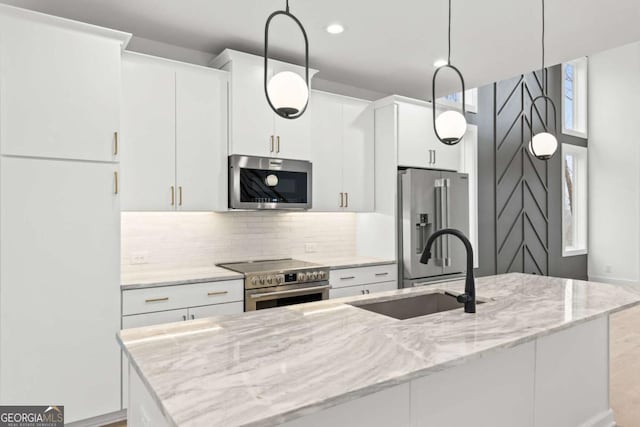 kitchen featuring white cabinetry, stainless steel appliances, decorative light fixtures, and sink