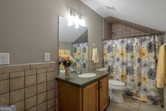 bathroom featuring tile walls, vaulted ceiling, and tile patterned floors