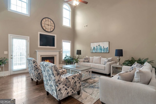 living room featuring hardwood / wood-style flooring, a healthy amount of sunlight, and ceiling fan