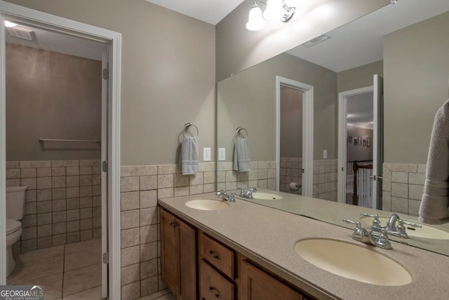 bathroom featuring tile walls, vanity, tile patterned flooring, and toilet