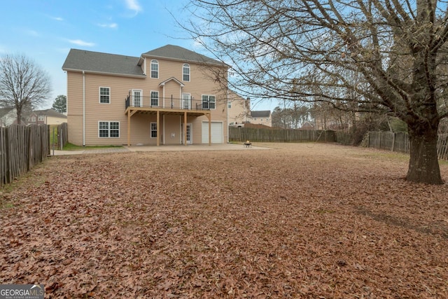 back of house with a garage and a patio