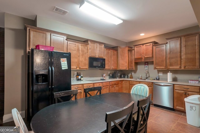 kitchen featuring light tile patterned floors, sink, and black appliances