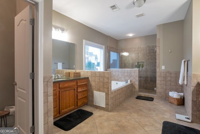 bathroom featuring tile patterned floors, vanity, shower with separate bathtub, and tile walls