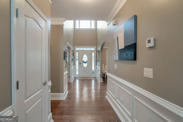 entrance foyer with ornamental molding and hardwood / wood-style floors