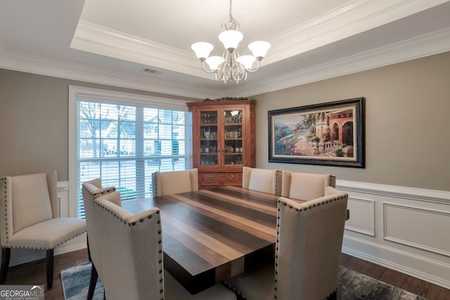 dining space featuring crown molding, a chandelier, dark hardwood / wood-style flooring, and a tray ceiling