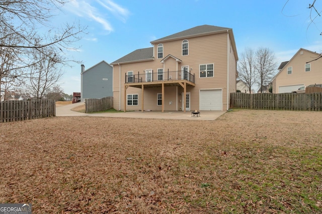 rear view of property featuring a garage, a patio, and a yard