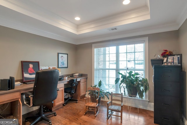 office area with hardwood / wood-style flooring, ornamental molding, and a raised ceiling