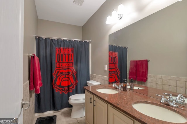 bathroom featuring vanity, toilet, tile patterned flooring, and tile walls