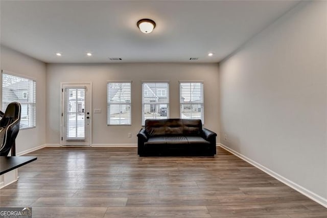 sitting room with dark wood-type flooring and a healthy amount of sunlight