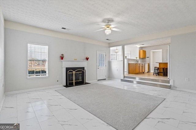 living room featuring ceiling fan and a textured ceiling