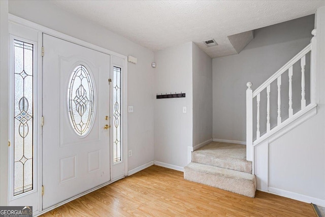 entryway featuring a textured ceiling and light wood-type flooring