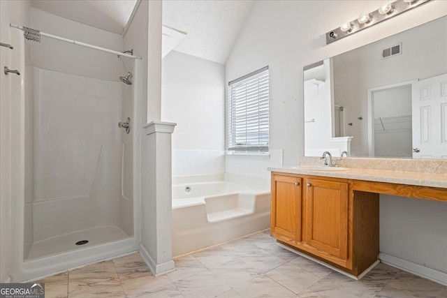 bathroom with vanity, lofted ceiling, a textured ceiling, and separate shower and tub