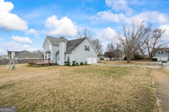 view of home's exterior featuring a garage, a lawn, and a deck