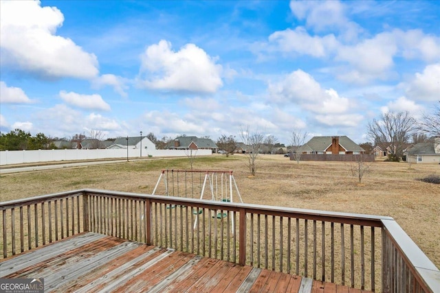 wooden terrace featuring a lawn and a playground