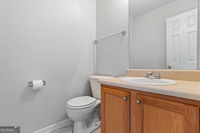 bathroom featuring vanity, toilet, and a textured ceiling