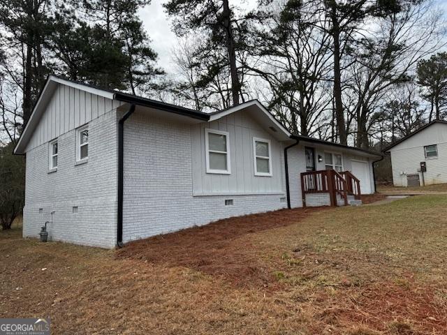 view of side of home with a yard and a garage