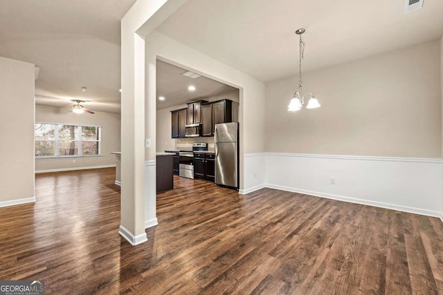 kitchen with stainless steel appliances, dark hardwood / wood-style floors, decorative light fixtures, and ceiling fan with notable chandelier