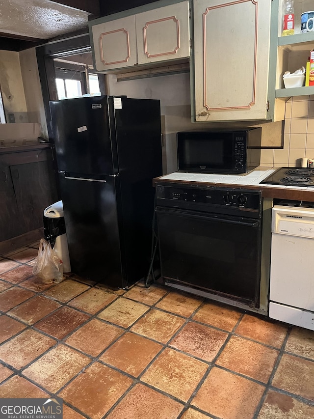 kitchen featuring backsplash, tile counters, and black appliances