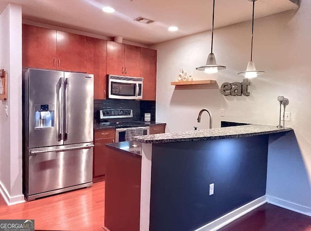 400 W Peachtree St NW Unit 3216, Atlanta, GA 30308 - kitchen featuring stainless steel appliances, visible vents, decorative backsplash, wood finished floors, and a peninsula