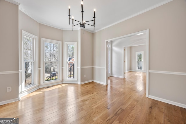 unfurnished dining area featuring crown molding, a notable chandelier, a wealth of natural light, and light wood-type flooring