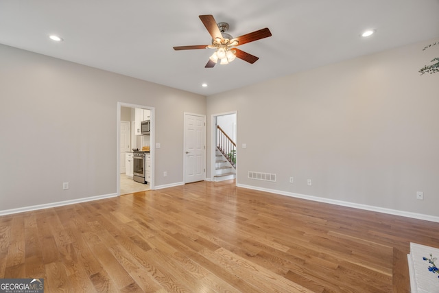 empty room with ceiling fan and light wood-type flooring