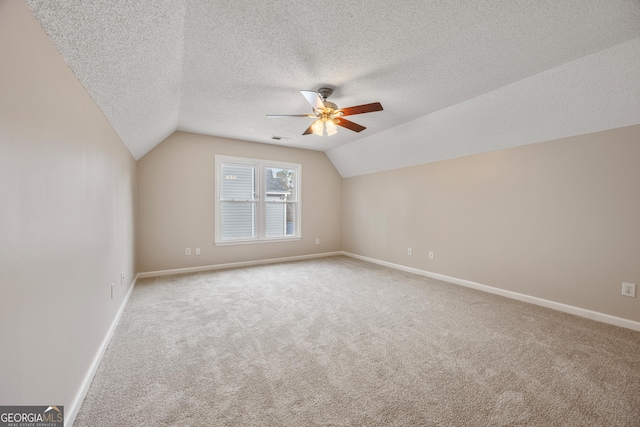 bonus room with lofted ceiling, a textured ceiling, ceiling fan, and carpet flooring